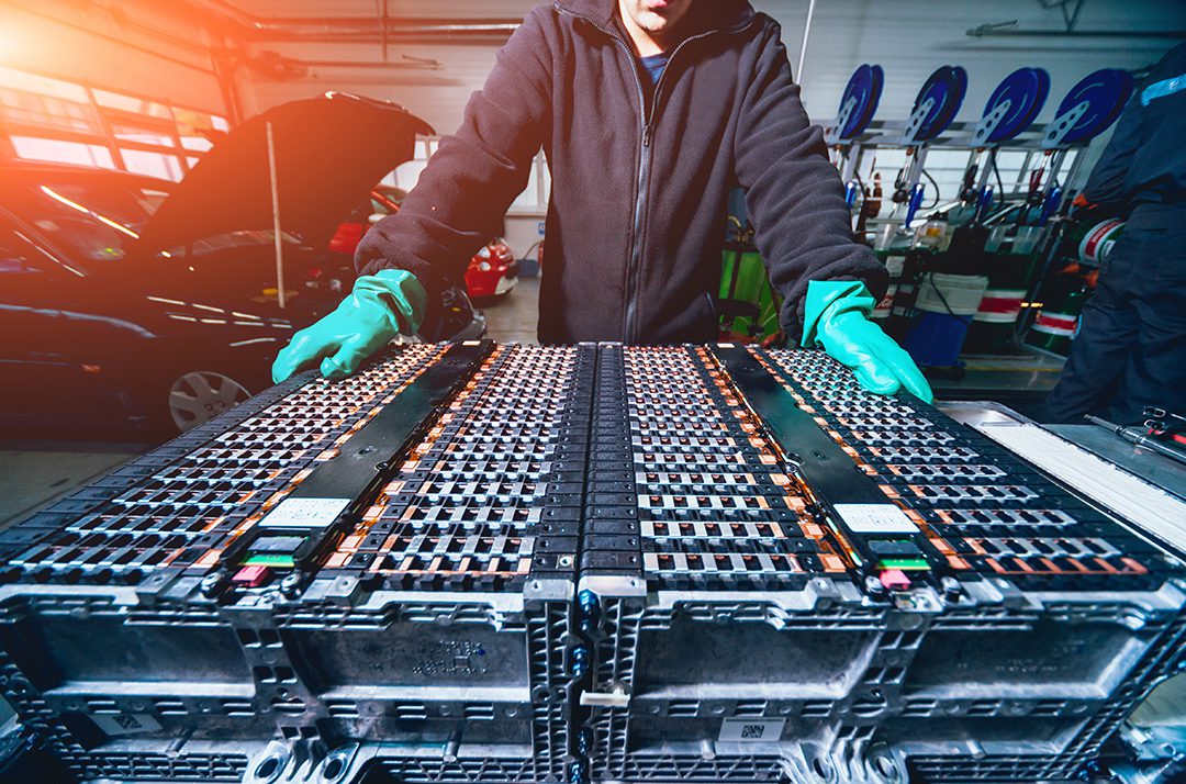 mechanic disassembling the battery of an electric vehicle engine
